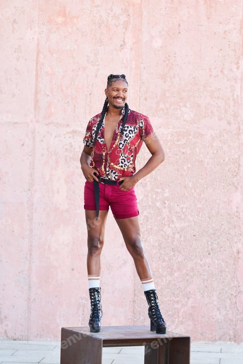 Preview: Stylish androgynous man posing on a bench outdoors