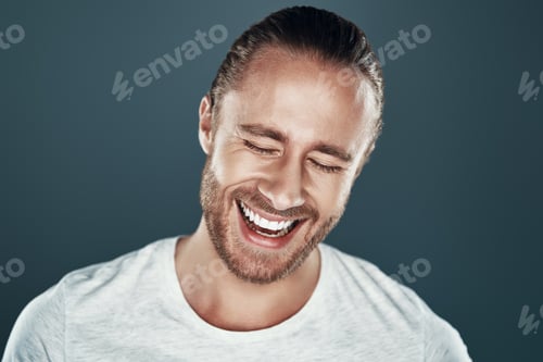 Preview: So handsome. Good looking young man smiling while standing against grey background