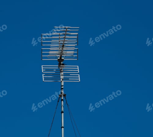 Preview: Tall television antenna under a deep blue sky with no clouds