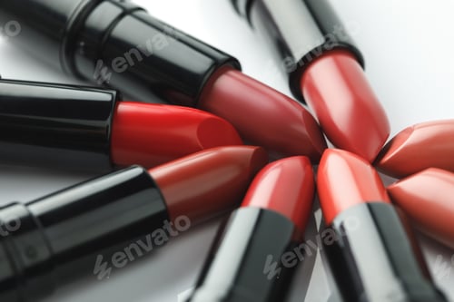 Preview: close-up shot of red lipsticks of various shades on white tabletop