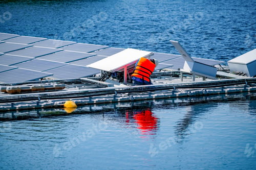 Preview: Local worker working at floating solar panels platform on the water of solar cell power plant.