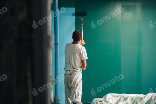Preview: Painter applying green paint on wall with roller