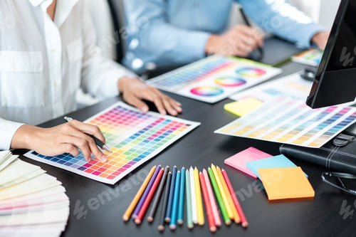 Preview: Two creative graphic designer team working on color selection and drawing on graphic tablet