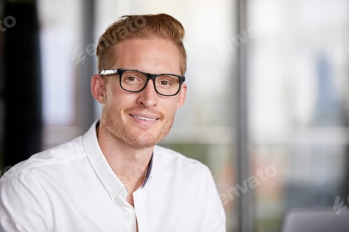Preview: Portrait of smiling redheaded businessman wearing glasses