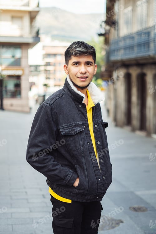 Preview: Latino man on the street with hands in jacket pocket looking at camera