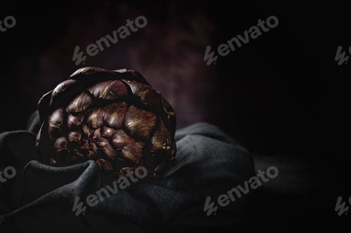 Preview: Fresh raw purple artichokes. On dark background.