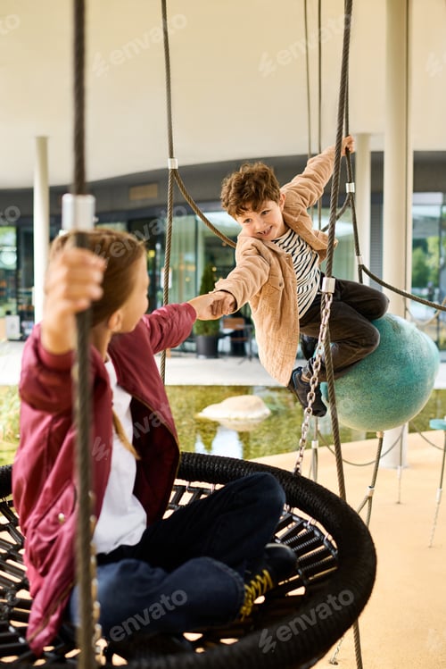 Preview: Playing joyfully together on swings in autumns golden glow during childhood bliss
