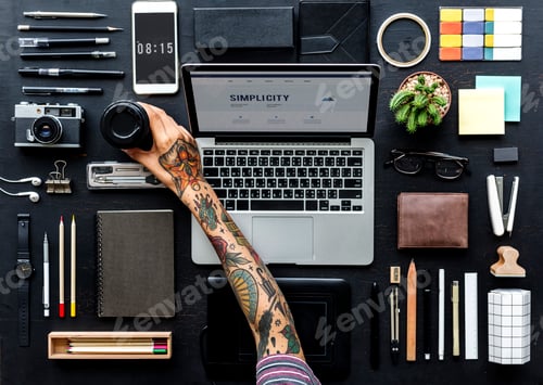 Preview: Aerial view of tattooed hand reaching for coffee