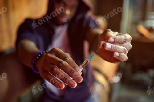 Preview: Drug addict man holds syringe with dose