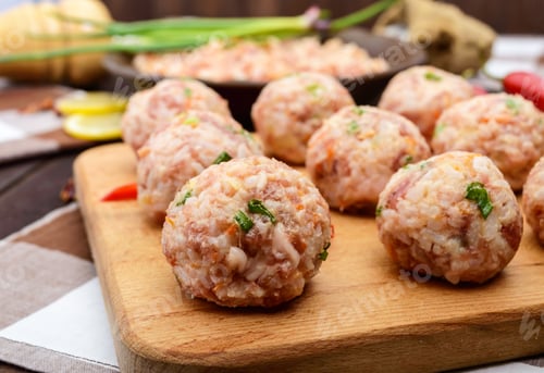 Preview: Raw meat balls, ready for cooking on a cutting board. Close up
