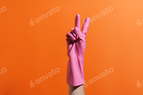 Preview: Woman's hand in rubber glove gesturing peace