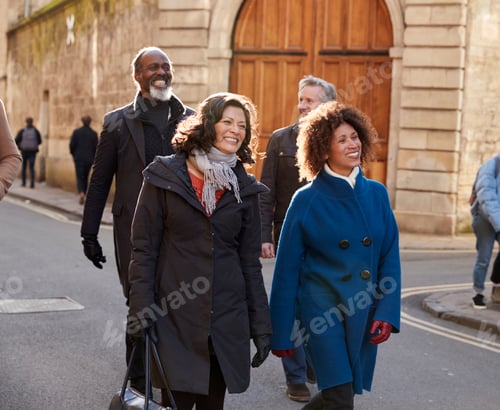 Preview: Group Of Mature Friends Walking Through City In Fall Together