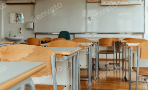 Preview: Selective focus image of chairs and tables in empty school classroom.