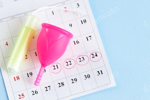 Preview: Calendar page and menstrual cup close up