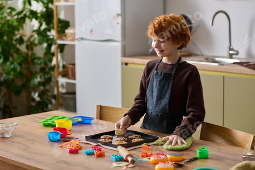 Preview: Joyful little boy bakes cookies in a cozy kitchen filled with colorful cooking tools