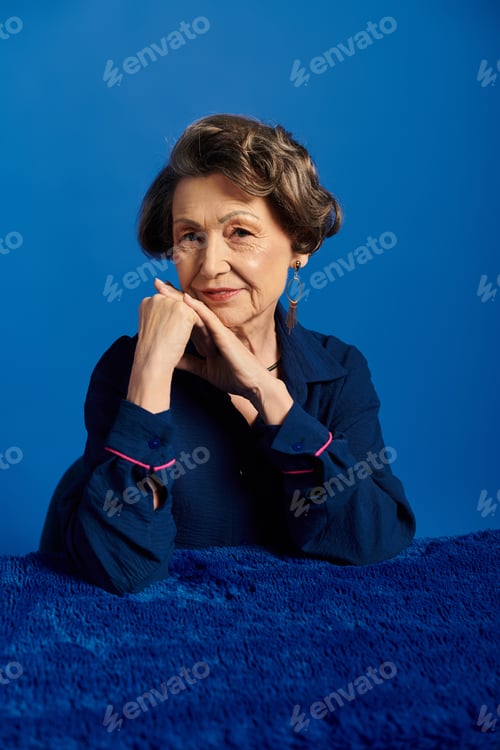Preview: A confident woman in trendy attire stands out against a bold blue background.