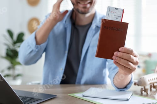 Preview: Travel agent with passport and ticket at wooden table in office, closeup