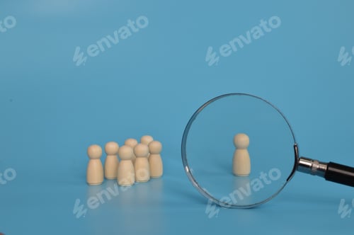 Preview: Magnifying glass is looking at the wooden figures of people