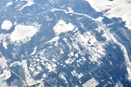 Preview: Aerial view from airplane window over clouds top to snow covered rivers, fields and roads
