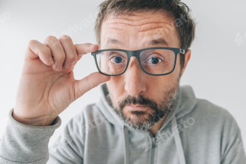 Preview: Man Holds Glasses, Looking at Camera