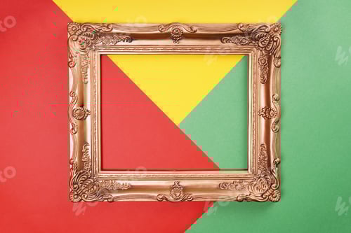 Preview: empty gold frame on color paper background in red green and yellow