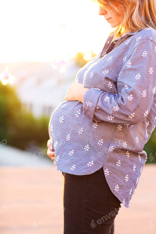 Preview: Pregnant woman against backdrop of city