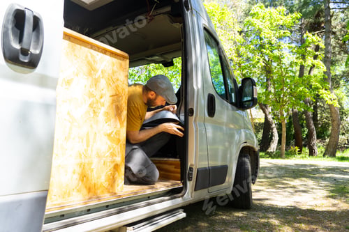 Preview: Caucasian man putting thermal insulation on a camper van