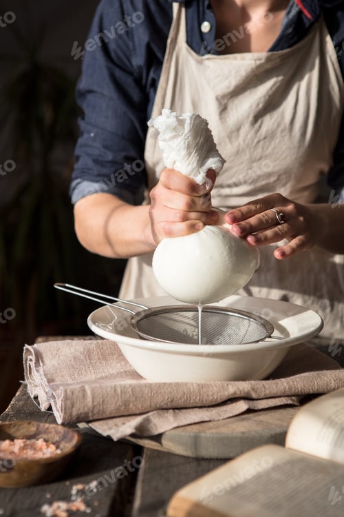 Preview: Preparation of cottage cheese - woman straining the milk through a cheesecloth