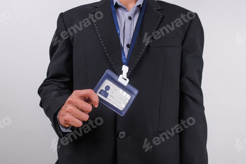 Preview: Close Up Of Businessman In Suit Holding Up Blue ID Badge With Blank Avatar Profile