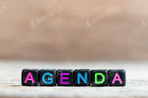 Preview: Black bead with color alphabet in word agenda on wood background