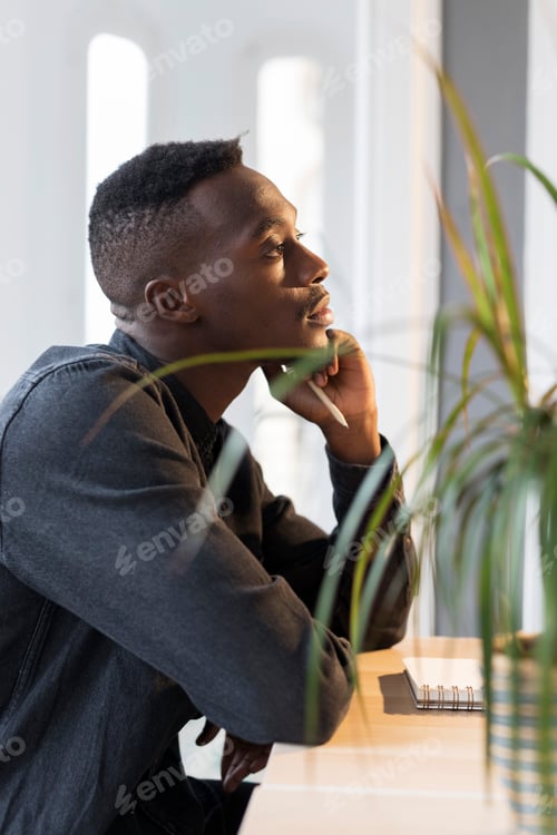 Preview: Pensive businessman sitting at dek in his office