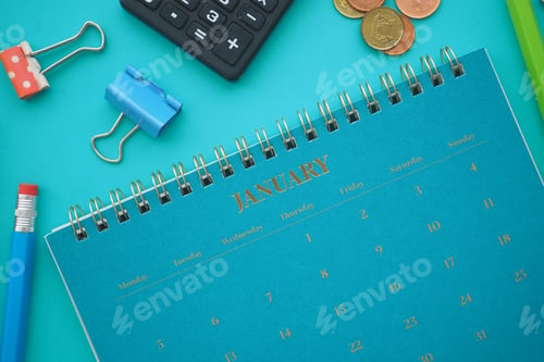 Preview: Calendar and office supplies on a blue table in January