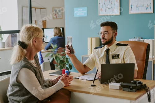 Preview: Visa Officer Inspecting Passport at Desk