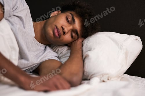 Preview: Deep sleep. Portrait of peaceful young guy sleeping in his cozy bed at home