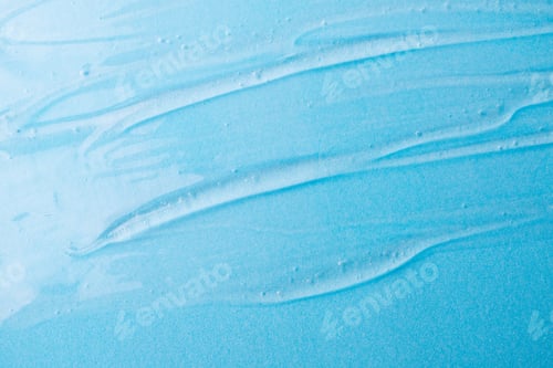 Preview: Liquid gel cosmetic on blue. Texture of blue gel or sanitizer. Transparent gel for face cleansing