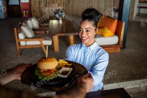 Preview: Waiter serves a fresh burger and fries in stylish restaurant, capturing the essence of great service