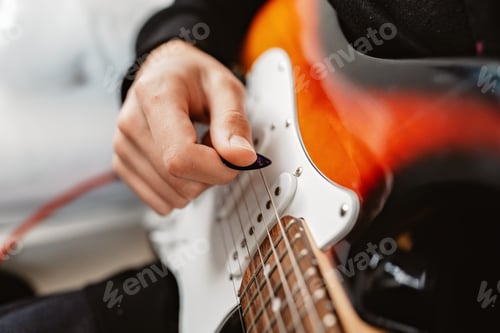 Preview: Young teenager boy hands playing electric guitar at home. Close up, selective focus.
