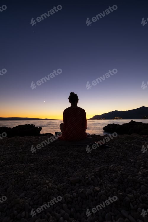 Preview: Silhouette girl on the sky background during sunset. Yoga and meditation.