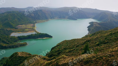 Preview: Untouched lagoon drone view in morning. Rough volcanic hills covered by greenery