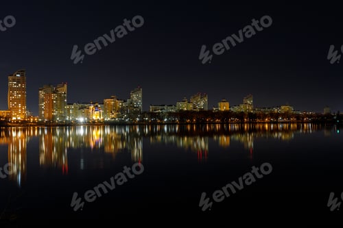 Preview: picturesque dark cityscape with illuminated buildings, river and night sky