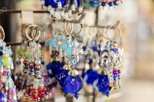 Preview: Keychains with intricate elephant designs and colorful beads hang from a display