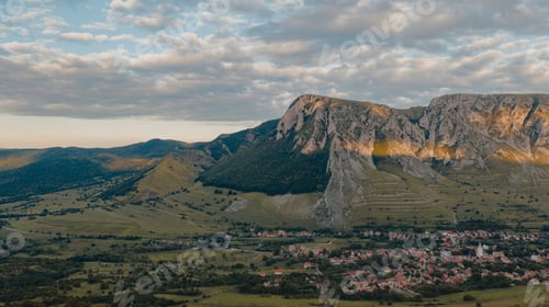 Preview: Sun setting over idyllic village with mountains. Meadow. Panoramic view of Rimetea, Transylvania