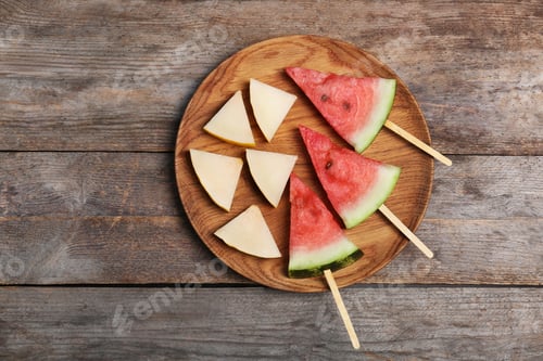 Preview: Watermelon and melon slices on wooden background, flat lay