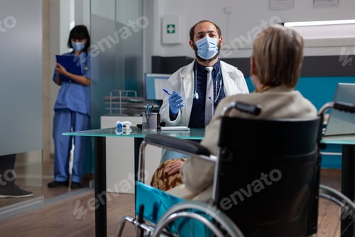 Preview: Medic meeting with retired woman in wheelchair at checkup visit