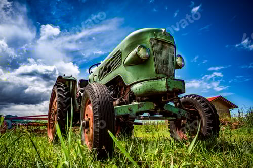 Preview: Antique Green Tractor Stands in Grassy Rural Field