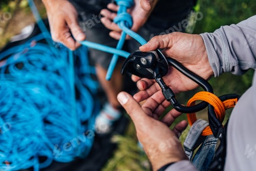 Preview: Close-Up of Hands Preparing Climbing Gear with Ropes and Carabiners