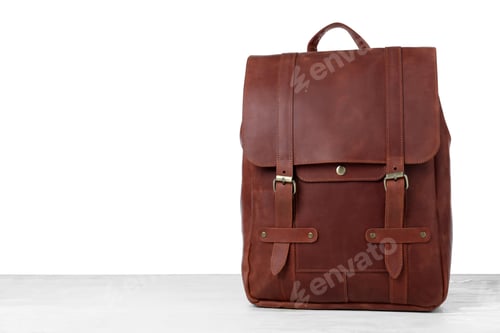 Preview: Stylish leather backpack on wooden table against white background. Space for text
