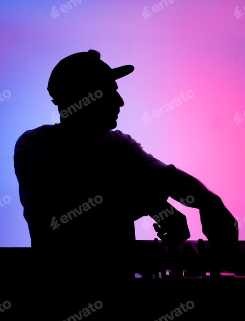 Preview: DJ session with colorful lights behind the performer at a local venue in the evening