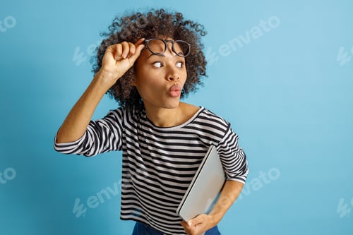 Preview: Afro American woman with portable laptop standing in studio