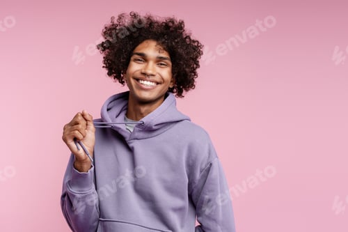 Preview: Portrait of smiling Latin man with piercing in nose wearing stylish purple hoodie looking at camera